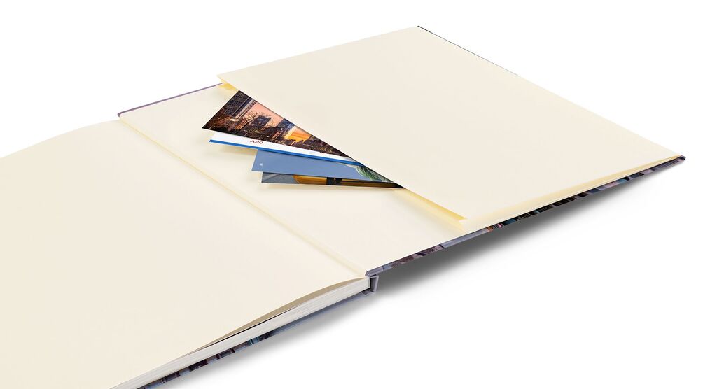 Album fotografico aperto con pagine vuote e foto inserite, ideale per ricordi.