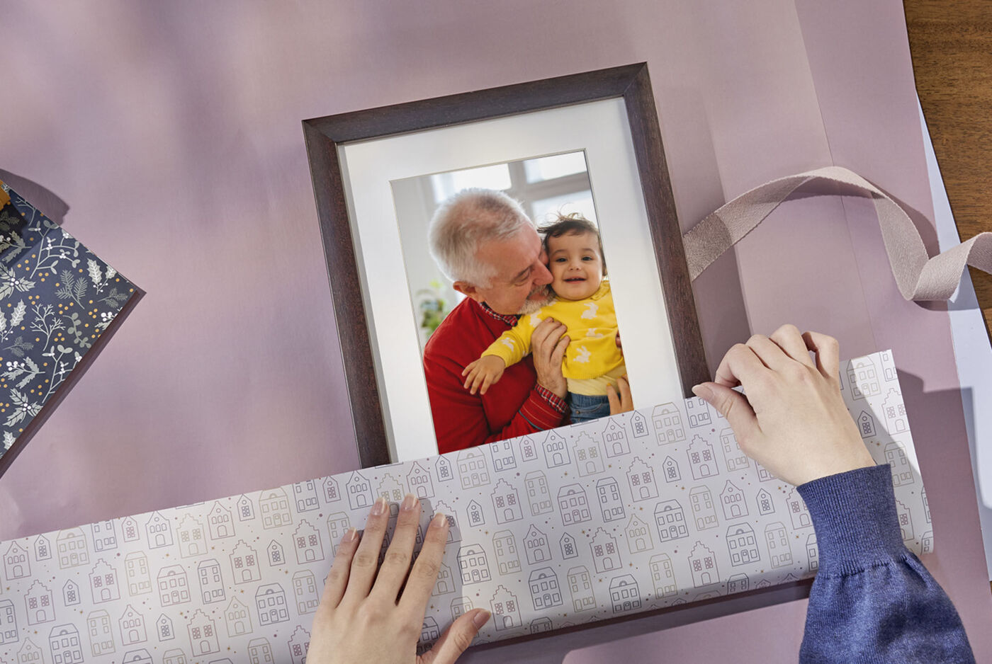 Una persona incarta un quadro in carta regalo, pronta a donarlo con amore.