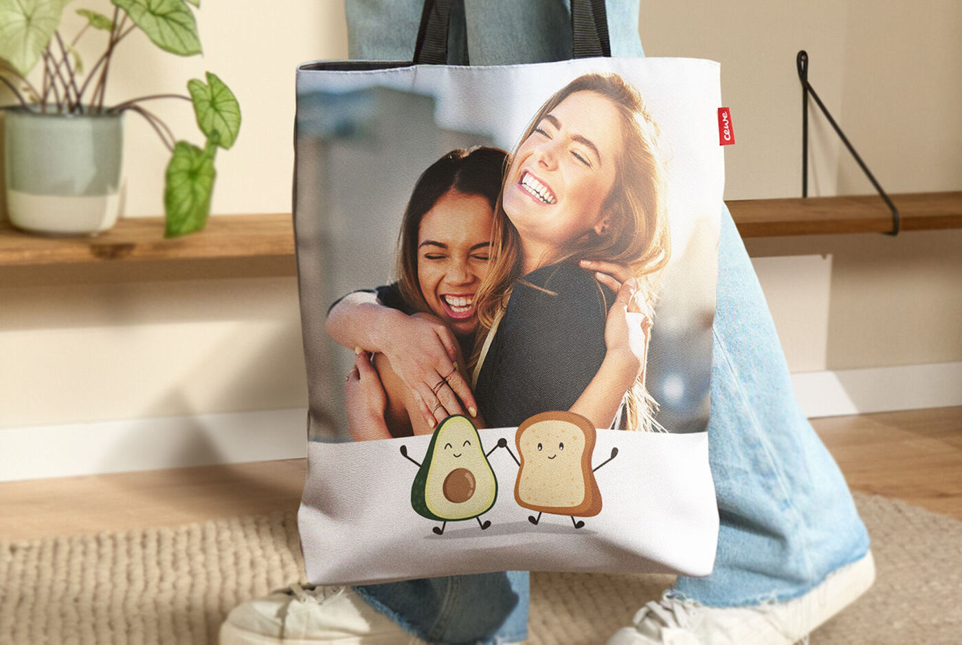 Una persona porta una borsa di stoffa con un motivo allegro di avocado e toast.