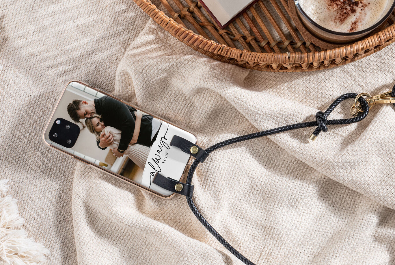 Telefono con foto personalizzata e elegante portachiavi su uno sfondo di stoffa chiara
