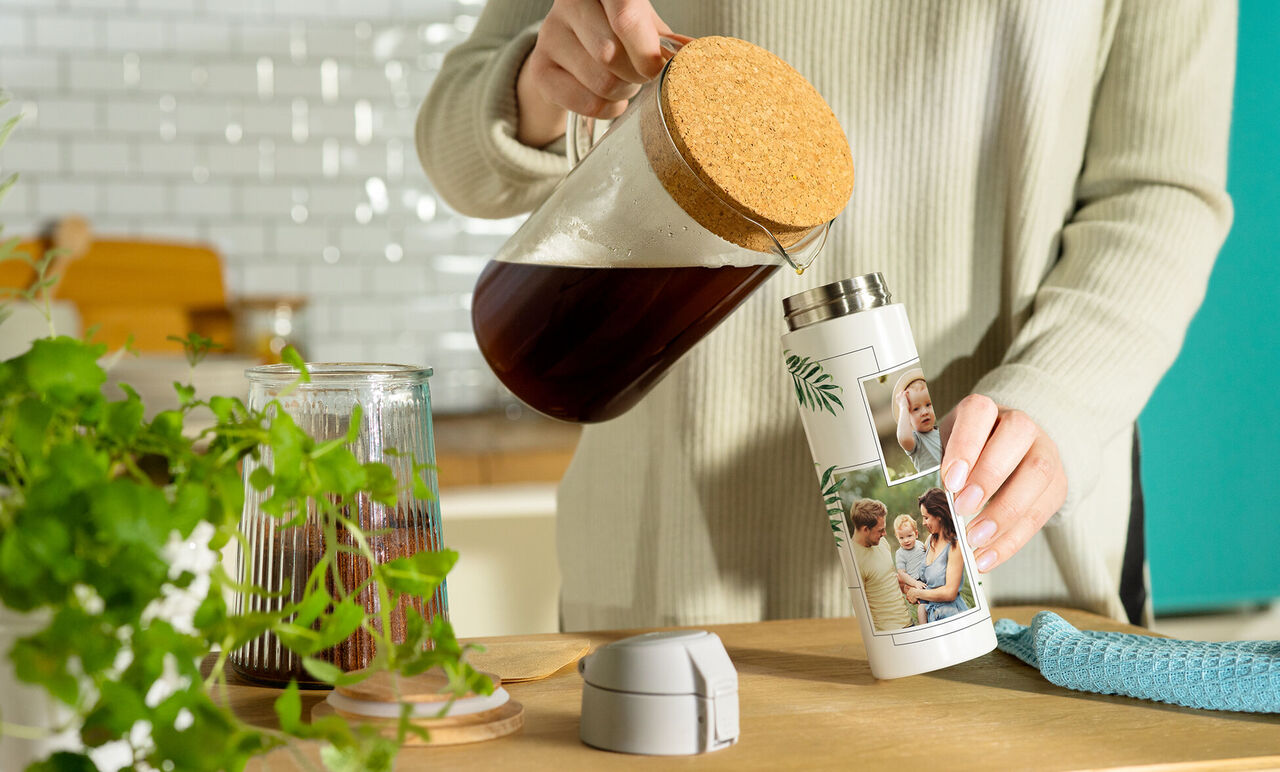 Una persona versa caffè in una termica personalizzata con foto.