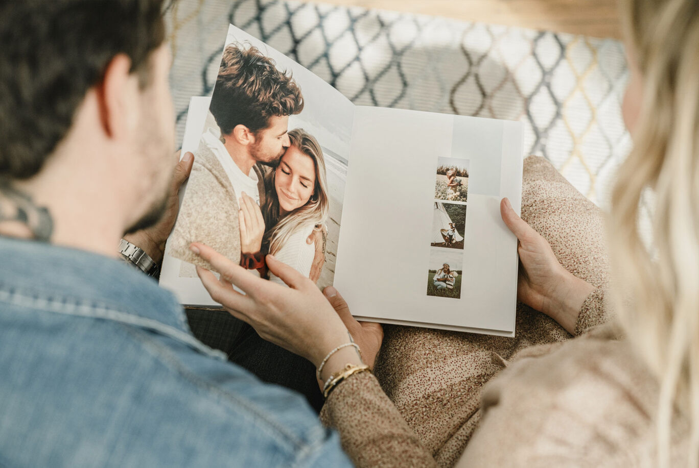 Una coppia guarda insieme un fotolibro aperto con ricordi.