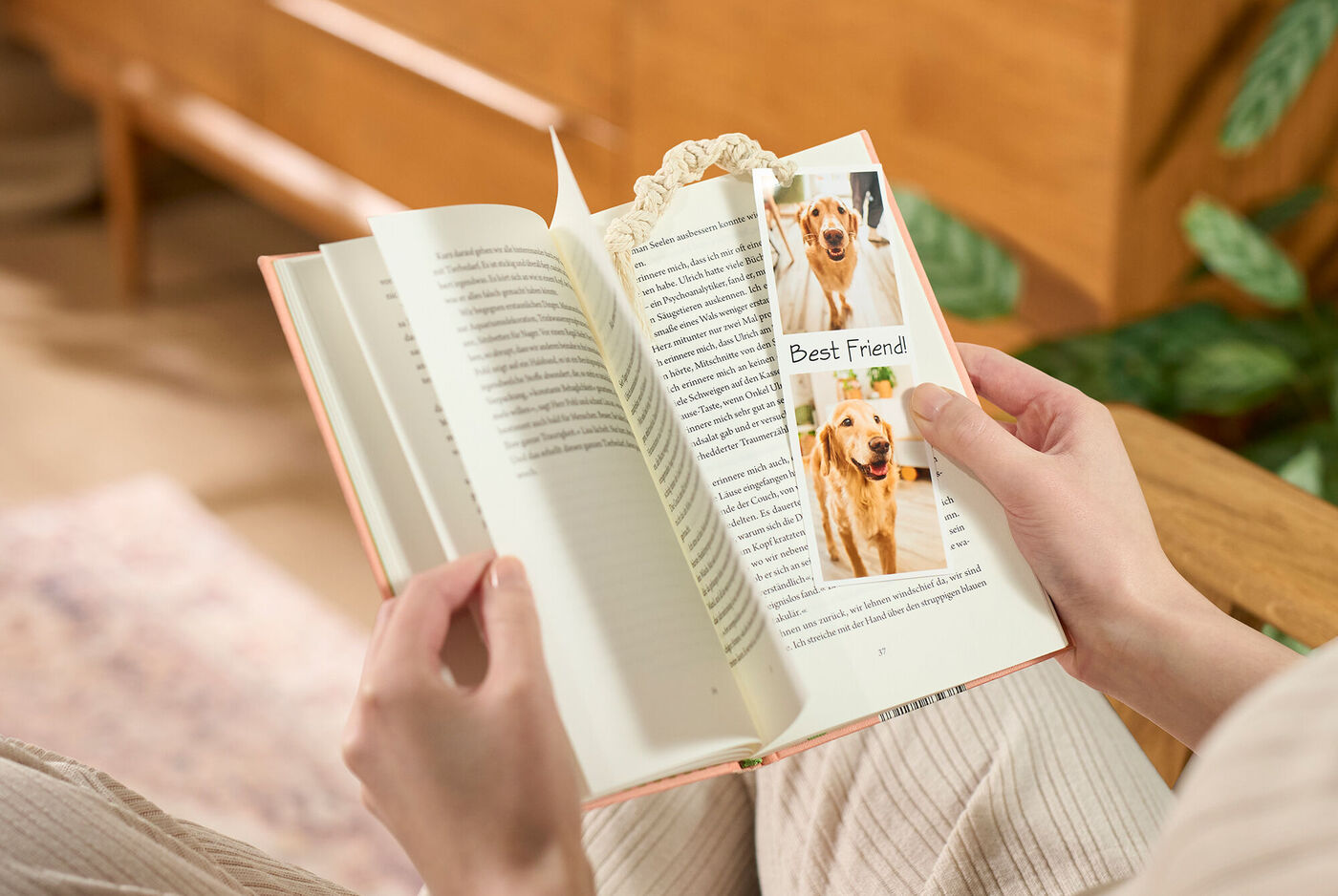 Una persona legge un libro tenendo un segnalibro con l'immagine del suo cane.